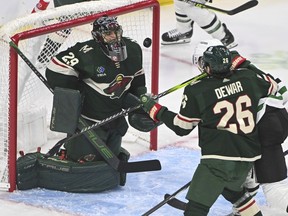 Minnesota Wild goalie Marc-Andre Fleury (29) blocks a shot by Dallas Stars center Radek Faksa, back right, as Wild center Connor Dewar tries to clear Faska from the goal during the first period of an NHL hockey game Sunday, Nov. 12, 2023, in St. Paul, Minn.