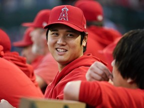 Los Angeles Angels' Shohei Ohtani talks with his translator in the dugout.