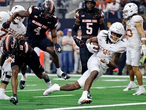 Texas Longhorns running back CJ Baxter scores a touchdown against the Oklahoma State Cowboys during the Big 12 Championship Game at AT&T Stadium in Arlington, Texas, on Saturday, Dec. 2, 2023.
