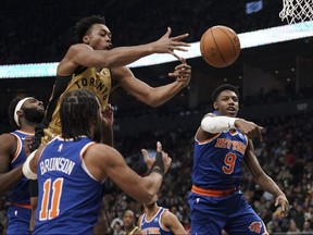 Raptors forward Scottie Barnes (4) jumps to shoot while being guarded by New York Knicks guards RJ Barrett (9), and Jalen Brunson (11).