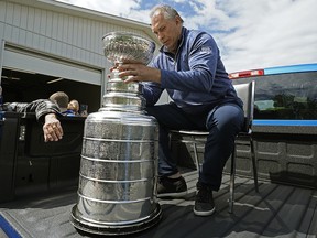 St. Louis Blues head coach Craig Berube rides with the Stanley Cup during a parade through the hamlet of Calahoo, Alta., on July 2, 2019.