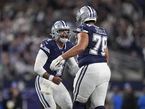 Dallas Cowboys quarterback Dak Prescott (4) reacts with offensive tackle Terence Steele (78) after throwing a touchdown pass against the Detroit Lions during the second half of an NFL football game, Saturday, Dec. 30, 2023, in Arlington, Texas.