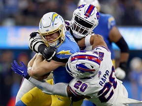 Easton Stick of the Los Angeles Chargers is tackled by Linval Joseph and Taylor Rapp of the Buffalo Bills at SoFi Stadium on December 23, 2023 in Inglewood, California.