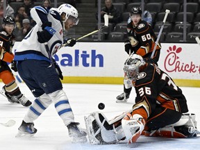 Anaheim Ducks goaltender John Gibson, right, stops a shot by Winnipeg Jets left wing Kyle Connor during the first period of an NHL hockey game in Anaheim, Calif., Sunday, Dec. 10, 2023. The Jets have placed leading scorer Connor on injured reserve with a knee injury.