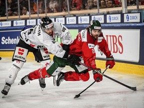 Canada's Josh Jooris, left, and Frolunda's Adam Brodecki, right, vie for the puck during the game between Frolunda HC and Team Canada, at the 95th Spengler Cup ice hockey tournament in Davos, Switzerland, Tuesday, Dec. 26, 2023.