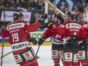 Canada's Zac Leslie, centre, celebrates with teammates after scoring against Kalpa Kuopio of Finland at the Spengler Cup in Davos, Switzerland, on Friday, Dec. 29, 2023.