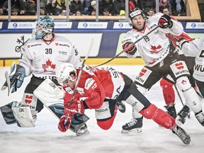 Canada goalkeeper Aaron Dell and Corban Knight battle with Pardubice's Lukas Sedlak during the Spengler Cup in Davos, Switzerland, Saturday, Dec. 30, 2023.