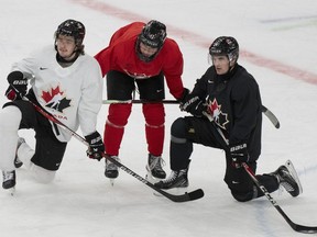 Canada's Conor Geekie (28), Macklin Celebrini (17) and Denton Mateychuk (24) listen to instructions during practice at the Scandinavium arena prior to the start of the IIHF World Junior Hockey Championship in Gothenburg, Sweden on Monday, Dec. 25, 2023. Canada will face Finland in its first game Dec. 26.