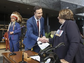 Manitoba Finance Minister Adrien Sala says the province has found some cost savings as it attempts to deal with a large deficit and keep its campaign promises. Premier Wab Kinew looks on as Sala is sworn-in by Lt. Gov. Anita Neville in Winnipeg on Wednesday, Oct. 18, 2023.THE CANADIAN PRESS/John Woods