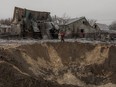 Communal workers walk next to a crater