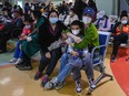 Parents wait with their children at a children's hospital in Beijing amid an increase in respiratory illnesses in parts of the country, November 23, 2023.