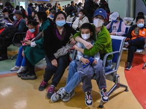 Parents wait with their children at a children's hospital in Beijing amid an increase in respiratory illnesses in parts of the country, November 23, 2023.