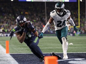 Jaxon Smith-Njigba of the Seattle Seahawks catches a pass for a touchdown at Lumen Field on December 18, 2023 in Seattle.