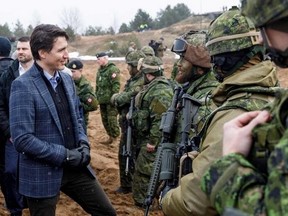 Prime Minister Justin Trudeau talks with soldiers during a visit of the Adazi military base, north east of Riga, Latvia, on March 8, 2022. (Photo by Toms Norde / AFP)