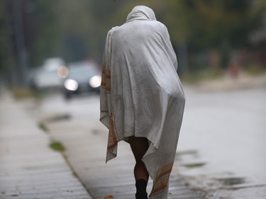 A person walks down a sidewalk with no shoes or pants while wearing a bed sheet, in Winnipeg. Chris Procaylo, Friday, Sept 15, 2023 Winnipeg Sun