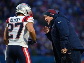 Head coach Bill Belichick of the New England Patriots talks with Myles Bryant during the second half of a game against the Buffalo Bills.