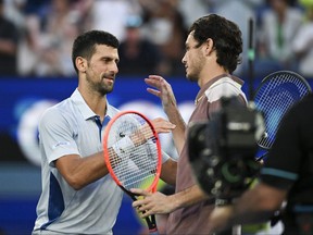 Serbia's Novak Djokovic (L) shakes hands with USA's Taylor Fritz after the end of their men's singles quarterfinal match.