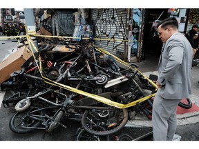 Charred remains of e-bikes and scooters sit outside of a building in Chinatown after four people were killed by a fire in an e-bike repair shop overnight on June 20, 2023 in New York City.