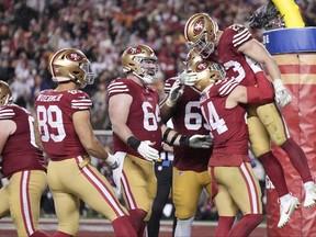 Christian McCaffrey, right, of the San Francisco 49ers celebrates with teammates after scoring a 6-yard rushing touchdown during the fourth quarter against the Green Bay Packers in the NFC Divisional Playoffs at Levi's Stadium on Jan. 20, 2024 in Santa Clara, Calif.