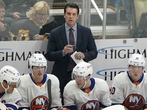 New York Islanders head coach Lane Lambert stands behind the bench during an NHL game against the Pittsburgh Penguins, Sunday, Dec. 31, 2023, in Pittsburgh.