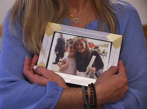 Lisa Loumakos holds an old photo of her mom Stella Skarmoutsos with her daughter Zoey, now 15, on Thursday, Jan. 25, 2024. Stella, 77, died of lung cancer in her daughter's Mississauga home on Sept. 22, 2023, before she was able to secure her permanent resident status so Lisa is now on the hook for $60,000 in medical bills.