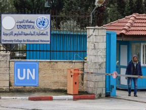 Palestinians stand at the entrance of the UNRWA-run University College for Educational Science Ramallah city in the occupied West Bank on Jan. 29, 2024.