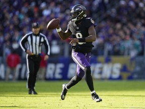 Baltimore Ravens quarterback Lamar Jackson looks to pass as he scrambles against the Miami Dolphins during the first half of an NFL football game in Baltimore, Sunday, Dec. 31, 2023.