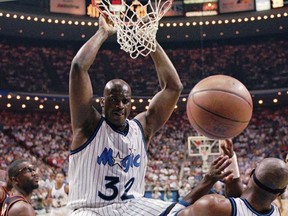 FILE - Orlando Magic center Shaquille O'Neal (32) hangs from the rim after a slam-dunk during the first quarter of their NBA basketball Eastern Conference semifinal game against the Atlanta Hawks, May 8, 1996, in Orlando, Fla. The Magic announced Thursday, Jan. 4, 2024, that they will retire O'Neal's No. 32 jersey on Feb. 13, 2024. He is the first Magic player to have his number retired.