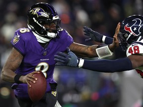 Lamar Jackson of the Baltimore Ravens stiff arms Christian Harris of the Houston Texans at M&T Bank Stadium on January 20, 2024 in Baltimore, Maryland.