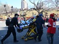 An injured person is aided by first responders near the Kansas City Chiefs' Super Bowl LVIII victory parade.