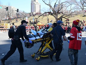 An injured person is aided by first responders near the Kansas City Chiefs' Super Bowl LVIII victory parade.
