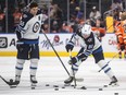 Winnipeg Jets' Mark Scheifele (55) and Cole Perfetti (91) warm up before taking on the Edmonton Oilers.