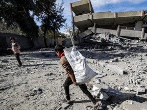 A boy carries a sack bearing the logo of UNRWA