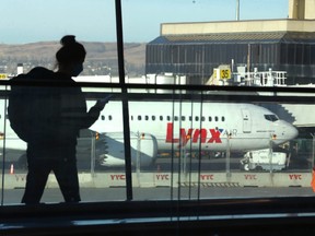 An airline passenger passes by the new Lynx Air Boeing 737 on the tarmac at the Calgary International Airport in Calgary on Thursday, April 7, 2022. Jim Wells/Postmedia