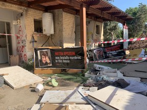 Signs showing the victims of Hamas's Oct. 7 massacre are seen outside ransacked homes in Kfar Aza, Israel.