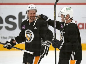 Pittsburgh Penguins' Erik Karlsson, left, shares a laugh with former Penguins player Jaromir Jagr who joined the team for a workout during NHL hockey practice, Saturday, Feb. 17, 2024, in Cranberry, Pa.