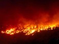 The McDougall Creek wildfire burns in the hills in West Kelowna, British Columbia, Canada, on August 17, 2023, as seen from Kelowna.