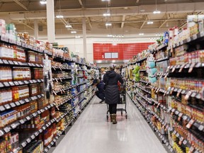 A shopper browses in an aisle at a grocery store In Toronto on Friday, Feb. 2, 2024.