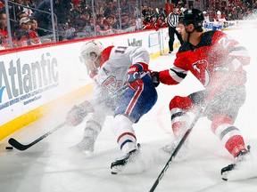 Colin Miller of the New Jersey Devils checks Brendan Gallagher of the Montreal Canadiens