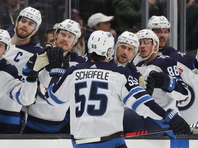 Jets centre Mark Scheifele celebrates at the bench after scoring the game-winning goal on Friday in Seattle.