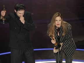 Arthur Harari, left, and Justine Triet accept the award for best original screenplay for "Anatomy of a Fall" during the Oscars on Sunday, March 10, 2024, at the Dolby Theatre in Los Angeles.
