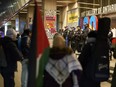 Police stand guard outside the Art Galley of Ontario in Toronto as protesters confront attendees of a reception for Prime Minister Justin Trudeau and Italian Prime Minister Giorgia Meloni which was cancelled following the protests, Saturday, March 2, 2024.