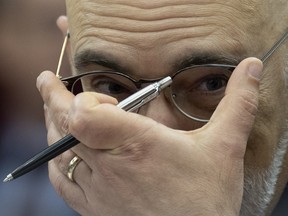 Parliamentary Budget Officer Yves Giroux adjusts his glasses as he waits to appear before the Senate Committee on National Finance, in Ottawa, Tuesday, Oct. 17, 2023.