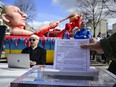 A protestor feeds an election ballot in to a shredder machine during a performance in front of an effigy of Russian President Vladimir Putin bathing in a bath of blood at a rally next to the Russian embassy in Berlin on March 17, 2024.