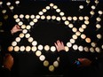 Women light candles in the shape of the Star of David during the symposium on fighting anti-Semitism on January 22, 2024 in Krakow, Poland.