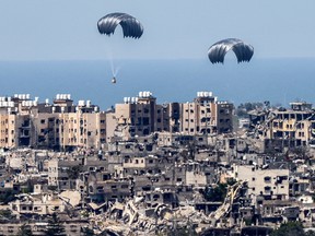 This picture taken from Israel's southern border with the Gaza Strip shows parachutes of humanitarian aid dropping over the besieged Palestinian territory on March 26, 2024.