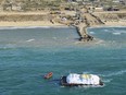 In this photo provided by the Israeli Army, humanitarian aid transported from a ship from the World Central Kitchen (WCK) organization, led by the United Arab Emirates, arrives in the Gaza Strip's maritime space, Friday, March 15, 2024. The Israeli military says a ship has delivered 200 tons of food, water and humanitarian supplies to Gaza, inaugurating a sea route from Cyprus. The sea route is intended to bring more assistance to alleviate the humanitarian crisis in the enclave five months into the war between Israel and Hamas.