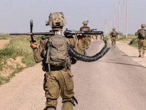 Israeli soldiers walk near the border with Gaza Strip