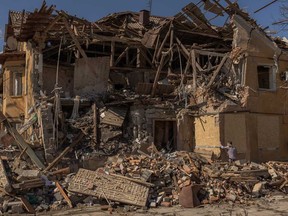 A man covers windows with plywood boards of a building that was heavily damaged following a recent shelling, in the town of Mykolaivka, near Sloviansk in the north of the Donetsk region, eastern Ukraine, on March 30, 2024, amid the Russian invasion of Ukraine.