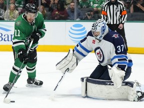 Jets goalie Connor Hellebuyck stares down a Stars shooter